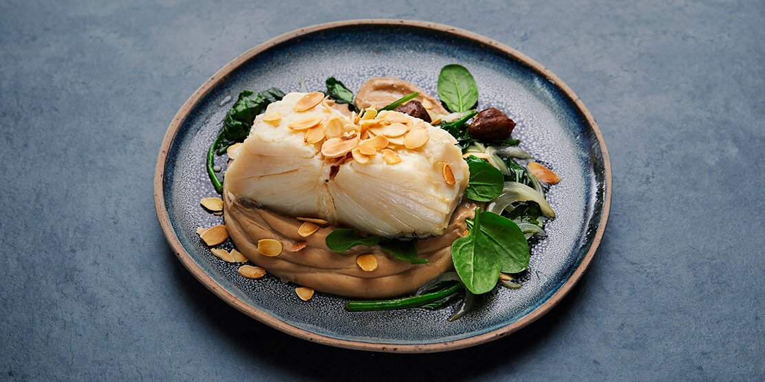 Bacalhau da Noruega confitado com purê de castanhas e cebolada de espinafres